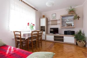 a living room with a dining room table and a kitchen at Apartments Hodanić in Krk +22 photos
