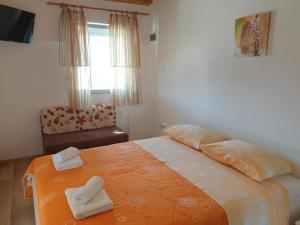 a bedroom with a bed with two towels on it at Apartments Hodanić in Krk