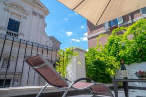 a chair and an umbrella in front of a building at Navona Open Space Apartments in Rome