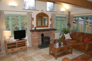 a living room with a couch and a fireplace at Honeysuckle Farm cottages in Glastonbury