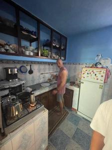 a man is standing in a kitchen at Cap sim surf house in Essaouira