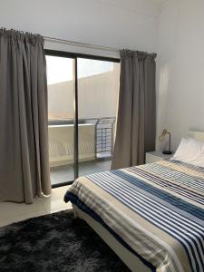 a bedroom with a bed and a large window at URBAN PARK UMHLANGA J001 in Durban