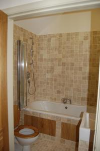 a bathroom with a toilet and a tub with a shower at Honeysuckle Farm cottages in Glastonbury +15 photos