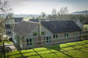 a house with a wooden fence in front of it at Honeysuckle Farm cottages in Glastonbury