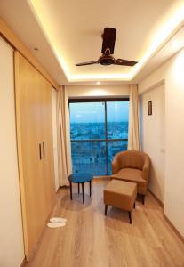 a living room with a couch and a chair and a window at Balconies & Venue ( The Grand Anukampa) in Jaipur