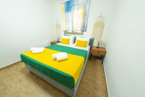 a bedroom with a bed with yellow and green at Villa Nuelle in Tílisos