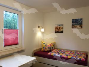 ein Schlafzimmer mit einem Bett und ein Fenster mit Fledermäusen an der Wand in der Unterkunft Ferienwohnung Fledermaus in Gelbensande