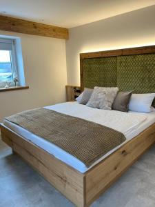 a bedroom with a large bed with a wooden headboard at Hotel Gasthof zum Wulfen in Sulzbach-Rosenberg