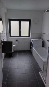 a bathroom with a tub and a sink and a bath tub at Ferienwohnung Sonne 