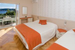 a bedroom with two beds and a view of a balcony at Bed & Breakfast Villa Vrgorac in Orebić