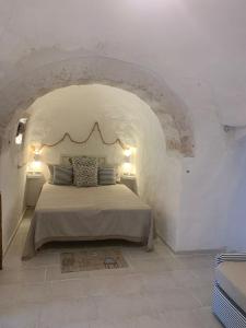 a bedroom with a bed in a white room at Trullo Lucia in Ostuni