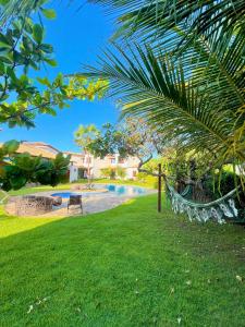 una hamaca en el césped junto a una piscina en Residência Conduru Preá, en Prea