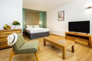 a living room with a bed and a television at Résidence Coeur Comédie in Montpellier