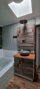 a bathroom with a sink and a bath tub at Wally's Edge 20acre Farm Stay in Rawson