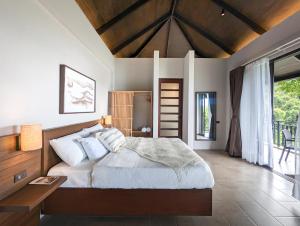a bedroom with a large bed and a wooden ceiling at Perch El Nido's Seaview Villas Maremegmeg in El Nido