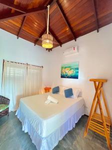 Residência Conduru Preá في بري: غرفة نوم بسرير في غرفة بسقوف خشبية