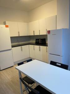 a kitchen with white cabinets and a table and refrigerator at love Romm in London