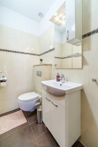 a white bathroom with a toilet and a sink at Peters apartment in Sutivan
