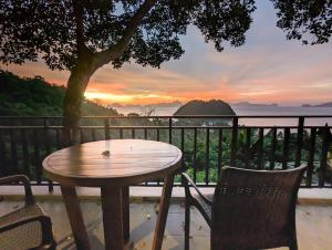 a wooden table and chairs with a view of the ocean at Perch El Nido's Seaview Villas Marimegmeg Beach in El Nido