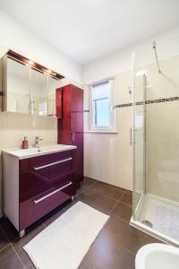 ein Bad mit einem Waschbecken und einer Dusche in der Unterkunft Peters apartment in Sutivan