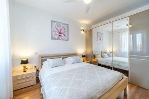 a bedroom with a large white bed and a mirror at Peters apartment in Sutivan