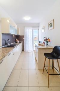 a kitchen with white cabinets and a black chair in it at Peters apartment in Sutivan