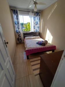 een kleine kamer met een bed en een raam bij Casa charmosa em ARMAÇÃO DOS BÚZIOS in Búzios