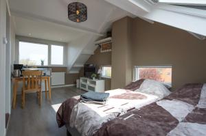 a bedroom with a bed and a desk in it at B&B de Noorman in Westkapelle