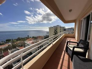 een balkon met 2 stoelen en uitzicht op de oceaan bij All Warmth - Colinas do Lido in Funchal