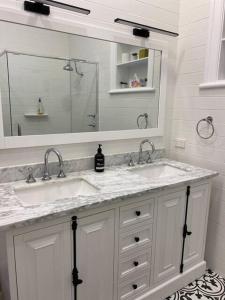 Baño blanco con 2 lavabos y espejo en Avon Homestay en Northam