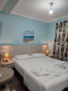 a large white bed in a room with two tables at Green House Skiathos in Skiathos