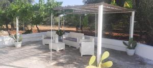 a patio with a gazebo and chairs and trees at Trullo Lucia in Ostuni