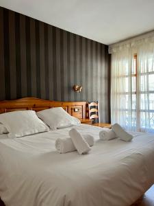 uma grande cama branca com duas almofadas brancas em Hotel Eriste em Eriste