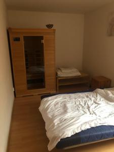 a bedroom with a bed and a wooden cabinet at Villapark apartments 201, Lipno in Lipno nad Vltavou