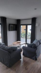 a living room with two couches and a table at Ferienwohnung Sonne in Stahlhofen +10 photos