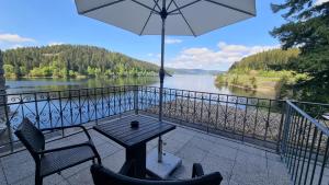 a table and chairs on a balcony with a view of a river at Seehotel Hubertus in Schluchsee