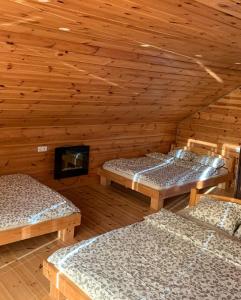 a room with three beds in a wooden cabin at Gerovės sodybėlė in Garliava