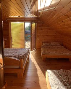 a bedroom with two beds in a wooden cabin at Gerovės sodybėlė in Garliava