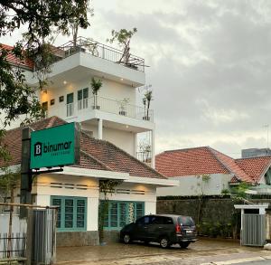 ein schwarzes Auto, das vor einem Gebäude geparkt ist in der Unterkunft Binumar Guest House in Pekalongan