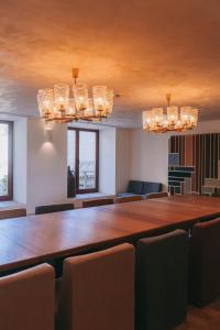 a large table in a room with chairs and chandeliers at Taboadella Casa Villae 1255 - Relais & Châteaux in Penalva do Castelo