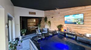 ein großer Pool in einem Haus mit einem TV an der Wand in der Unterkunft La suite Volupté - SPA du Souffle du Saule in Buhl-Lorraine