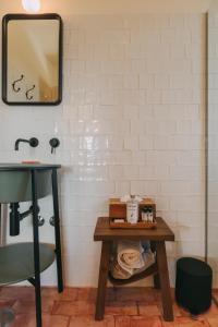 a bathroom with a table and a mirror at Taboadella Casa Villae 1255 - Relais & Châteaux in Penalva do Castelo