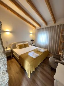Douro Pateo House في فيلا نوفا دي غايا: غرفة نوم بسرير كبير وأريكة