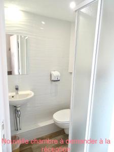 a white bathroom with a toilet and a sink at Première Classe Troyes Sud - Buchères in Buchères
