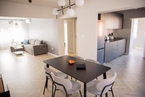 a kitchen and a dining room with a table and chairs at Sabrini Residence B3 Timisoara Old Town in Timişoara