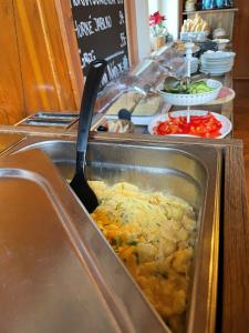 a buffet line with a casserole dish of food at Horský Hotel Dobrá Chata in Stachy