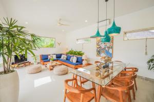 een woonkamer met een glazen tafel en een blauwe bank bij Villa Bonsai Kecil Pererenan in Munggu