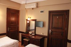 a hotel room with a bed and a desk with a mirror at Hotel SultanHill in Istanbul
