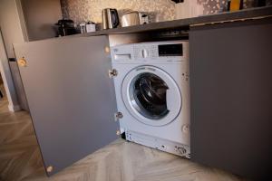 a washing machine under a counter in a kitchen at Sabrini Residence B3 Timisoara Old Town in Timişoara +15 photos