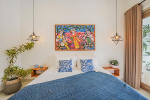 een slaapkamer met een bed en een schilderij aan de muur bij Villa Bonsai Kecil Pererenan in Munggu